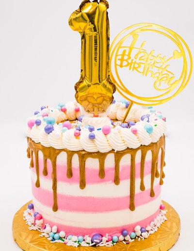 Pink striped first year birthday cake.